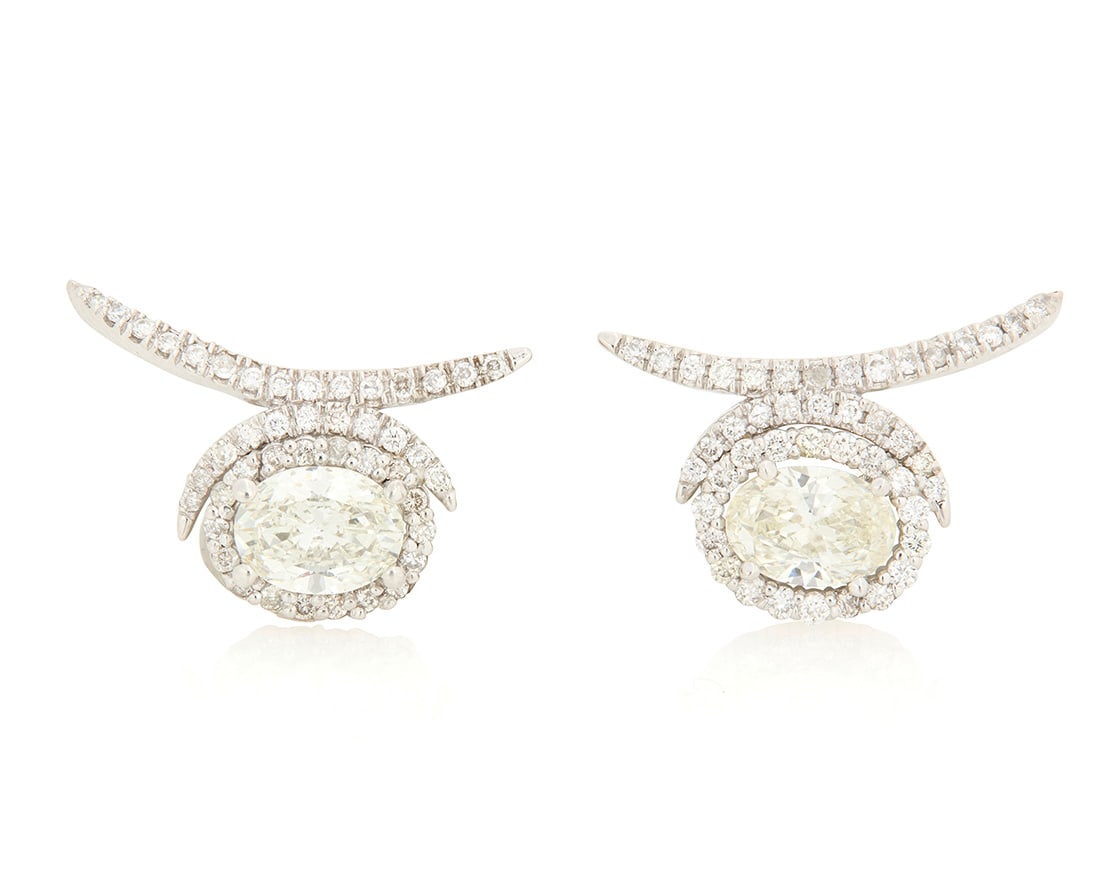 A Pair of White Gold and Diamond Earrings: A Pair of White Gold and Diamond Earrings Of a spray design centering two oval diamonds weighing 0.78 and 0.80 carat, accented by round diamonds 2 pieces Measures: 7/8 x 1/2 in. 4.8 grams gross