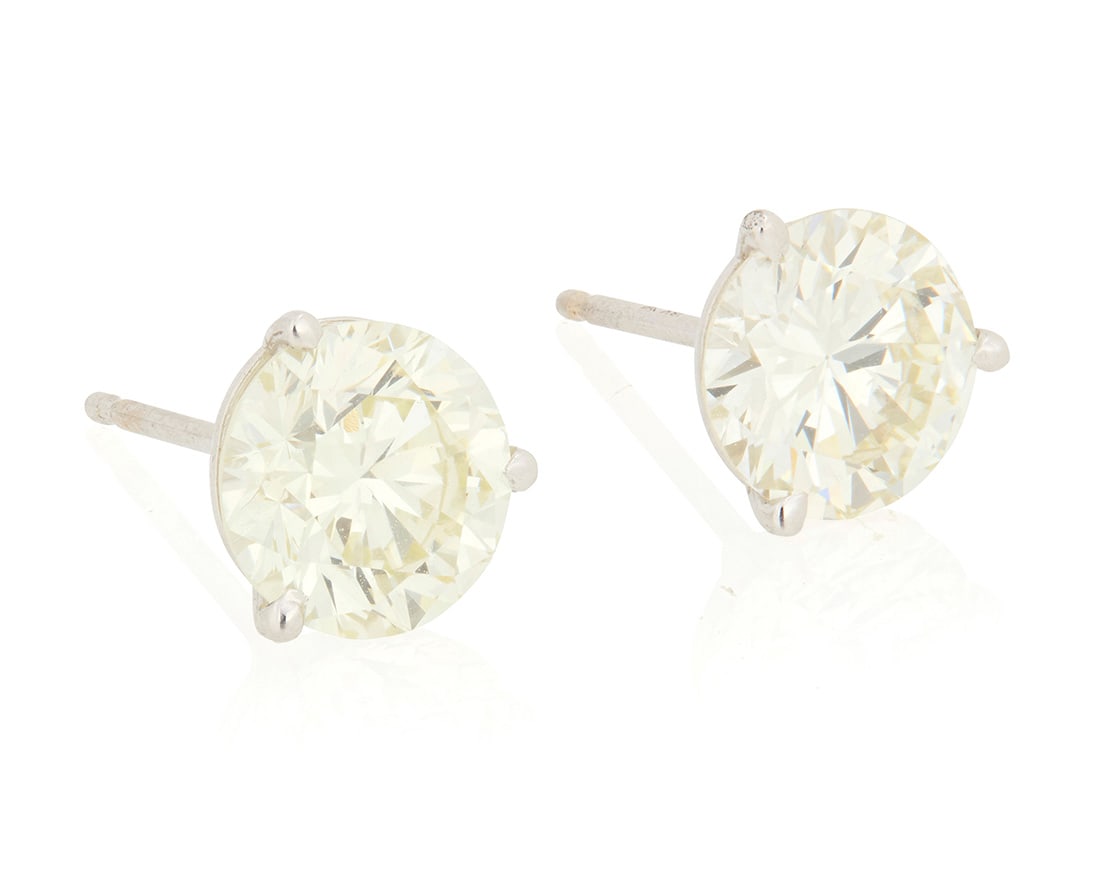 A Pair of 18K White Gold and Diamond Stud Earrings: A Pair of 18K White Gold and Diamond Stud Earrings Featuring two round diamonds weighing approximately 1.54 and 1.36 carats, ina three prong setting 2 pieces Measures: 3/8 in. 1.4 grams gross