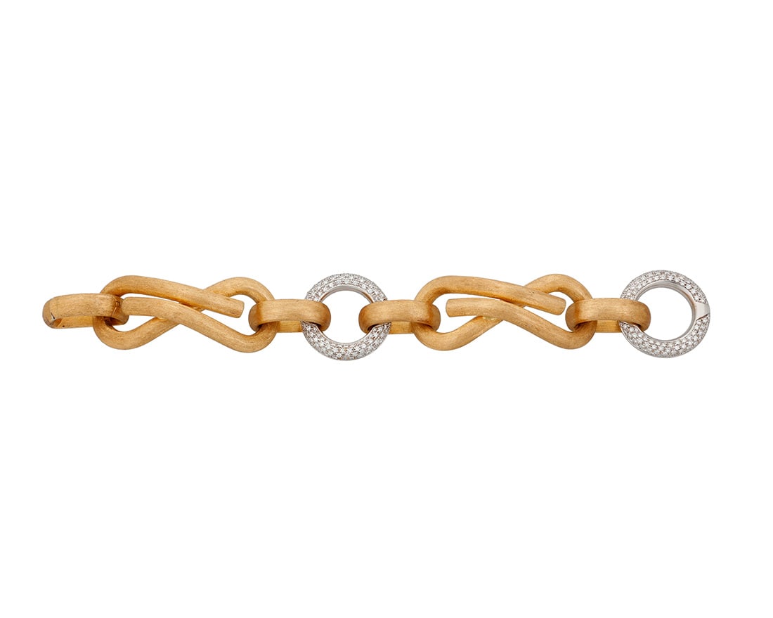 Nicolis Cola: An 18K Bi-Color Gold and Diamond Bracelet: Nicolis Cola: An 18K Bi-Color Gold and Diamond Bracelet Featuring two large intricate knotted links of brushed gold, finished with two white gold circular connectors set with round diamonds weighing