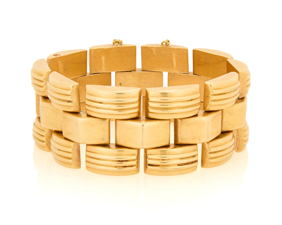 An 18K Gold Bracelet: An 18K Gold Bracelet Of a brick design featuring high polish and fluted links Length: 7 in., Width: 1 1/8 in. 71.9 grams gross