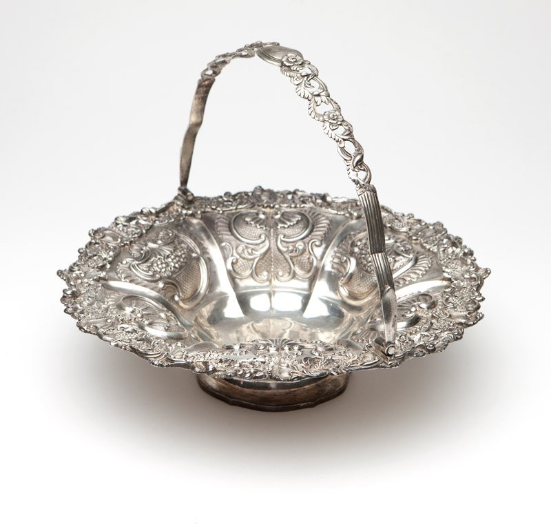A George IV sterling silver basket, J E Terrey: 1828, London, maker's mark of John Edward Terrey, circular, the pierced floral and foliate-scrolled swing handle over a pierced floral, grape cluster, scroll and shell-decorated rim applied to a lobed