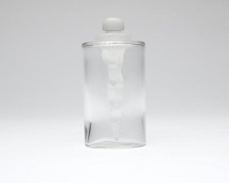 A rare Rene Lalique 'Jeunesse' perfume bottle: 1935, signed ''R. Lalique'', of clear and frosted colorless glass, the cylindrical body surmounted by a domed, circular stopper extending to a dauber modeled as a standing cherub, 4.125'' H x 2'' Dia.