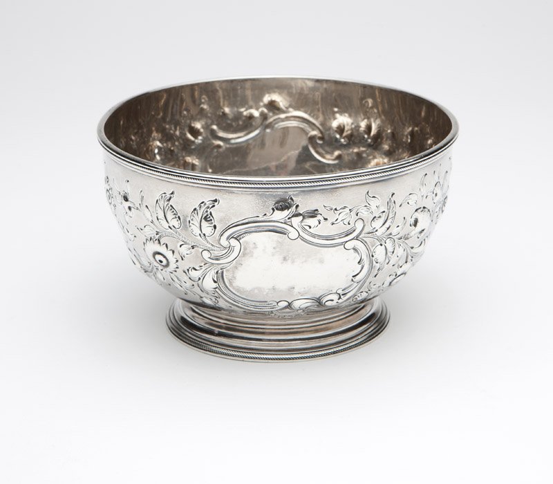 A W. Forbes coin silver bowl: Circa 1850, stamped ''W. Forbes'' (William Forbes) and ''New York'', the circular gadrooned rim over a tapering body decorated with repousse flowers, foliage and C-scrolls, on a spreading circular foo
