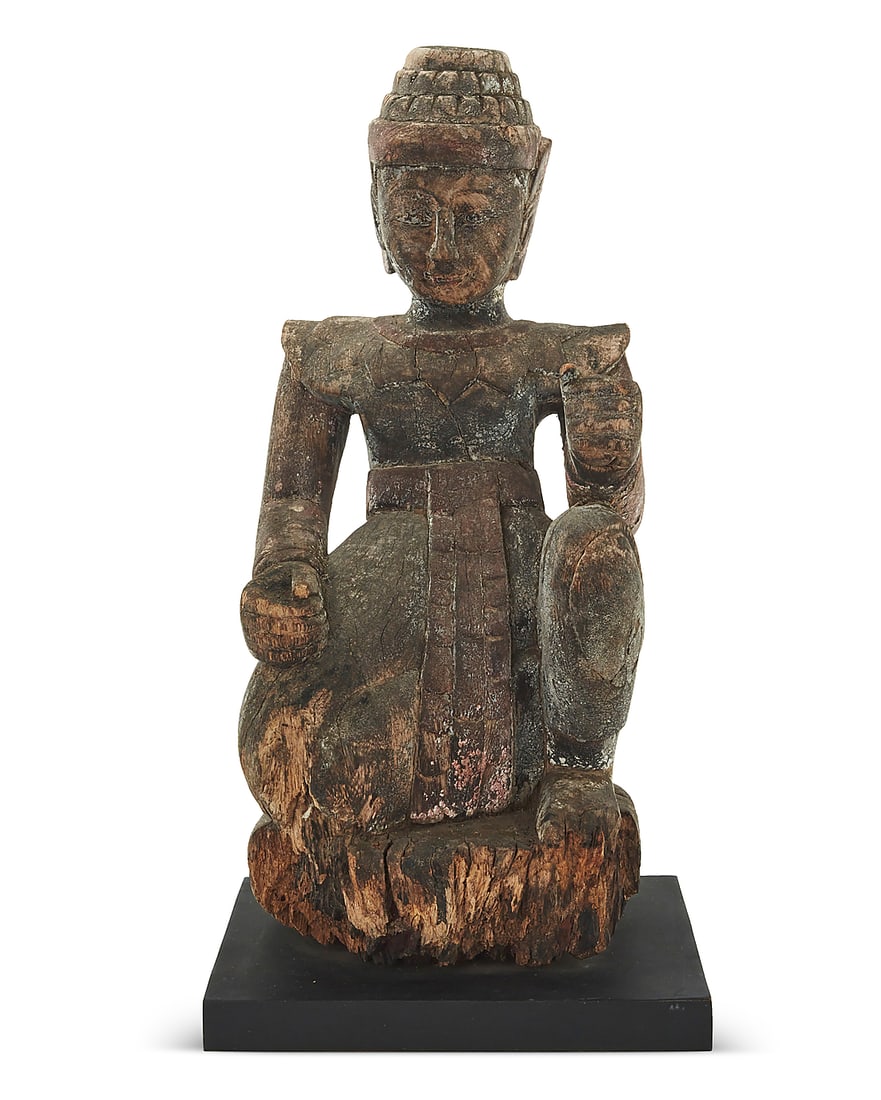 A Khmer style carved wood Nat: A Khmer style carved wood Nat Likely 19th century Raised on an enameled wood base Figure: 19" H x 8.5" W x 8.5" D; Overall: 19.875" H x 10.125" W x 10.125" D