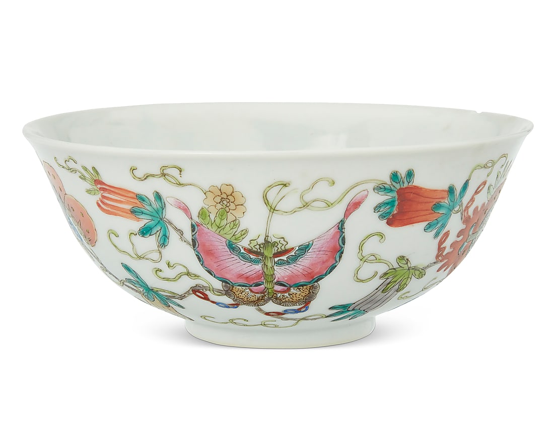 A Chinese enameled porcelain bowl: A Chinese enameled porcelain bowl First half 20th century Bearing red painted reign mark for Qianlong Period (1736-1795); stamped: CHINA Depicting butterflies and flowers 2.625" H x 6.375" Dia.