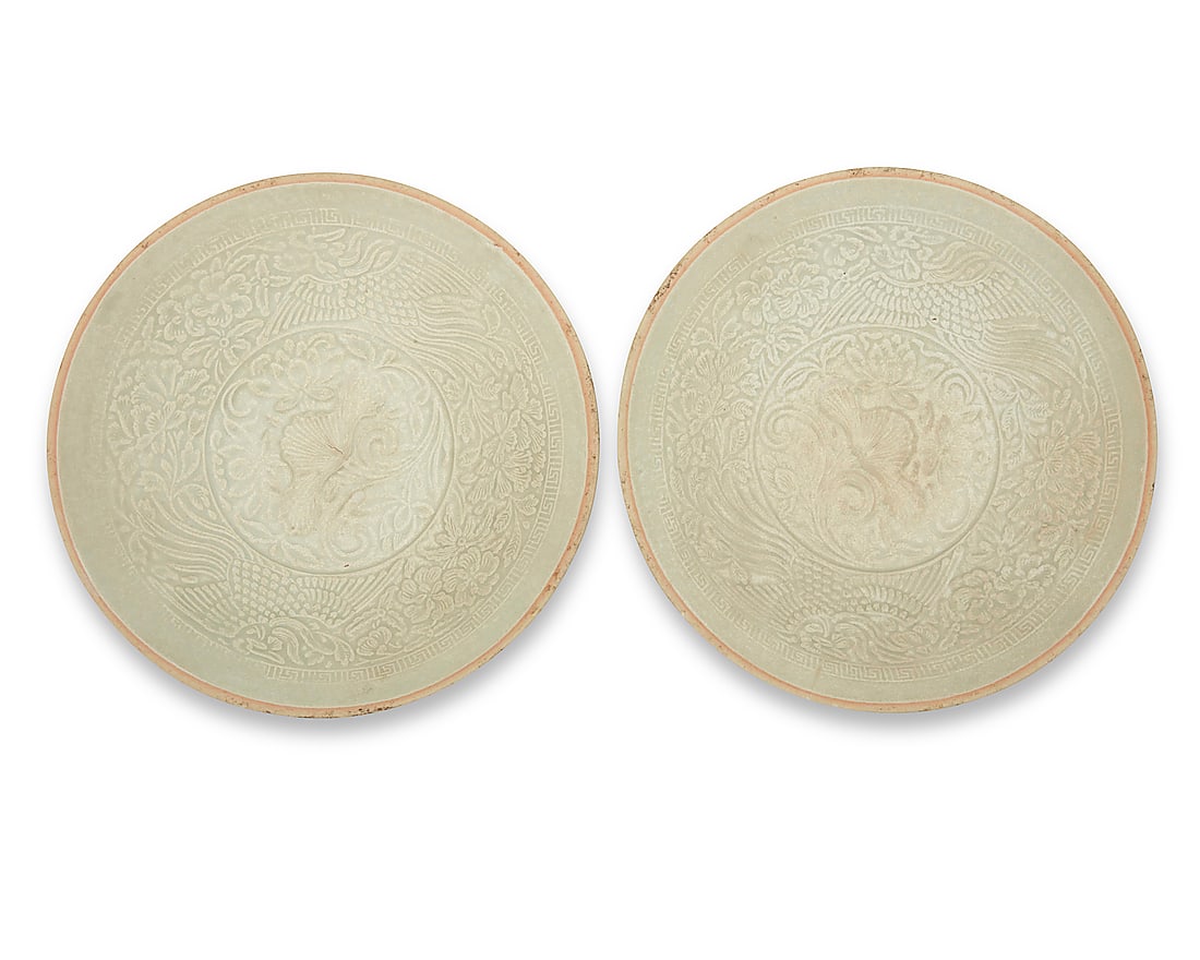 A pair of Chinese molded ceramic qingbai bowls: A pair of Chinese molded ceramic qingbai bowls Yuan Dynasty (1271-1368) or later Each with pale green partial glaze, depicting birds and floral motifs within a meandering border 2 pieces Each: 1.625"