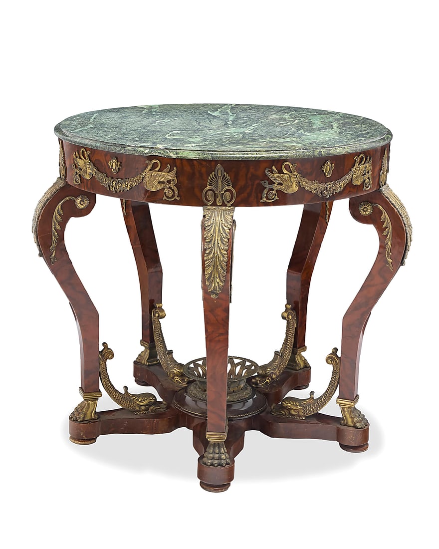 An Empire style bronze-mounted mahogany center table: An Empire style bronze-mounted mahogany center table Late 19th/early 20th century With green marble top, mounted with palmettes, swans, dolphins, and paw feet, raised on five cabriole legs joined by a