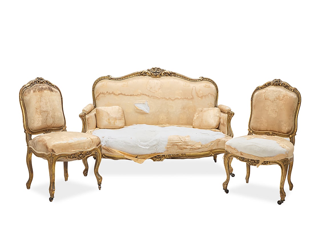 A Louis XV style salon suite: A Louis XV style salon suite 19th/20th century Comprising a pair of side chairs and a settee, each with giltwood frame carved with foliate motifs, upholstered in a beige silk damask fabric 3 pieces Ea