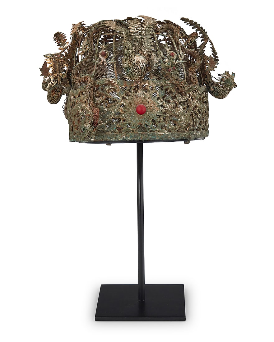 A Chinese silver metal filigree wedding headdress: A Chinese silver metal filigree wedding headdress Qing Dynasty (1644-1912) or later A large elaborate mixed metal wire and mesh crown with filigree border featuring dragon motifs and a central sunburs