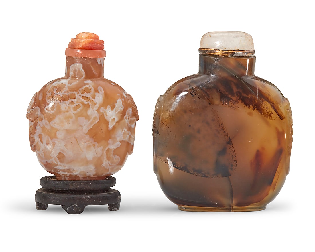 Two Chinese carved agate snuff bottles: Two Chinese carved agate snuff bottles Qing Dynasty (1644-1912) or later Comprising one butterscotch agate raised on a carved wood stand, and another agate bottle, each carved with opposed beast masks