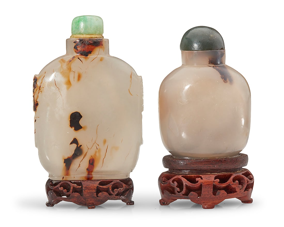Two Chinese carved agate snuff bottles: Two Chinese carved agate snuff bottles Late Qing Dynasty (1644-1912) or later Each shadow agate raised on a carved wood stand, one with opposed beast masks in relief 2 pieces Taller: 3.25" H x 2.125" 