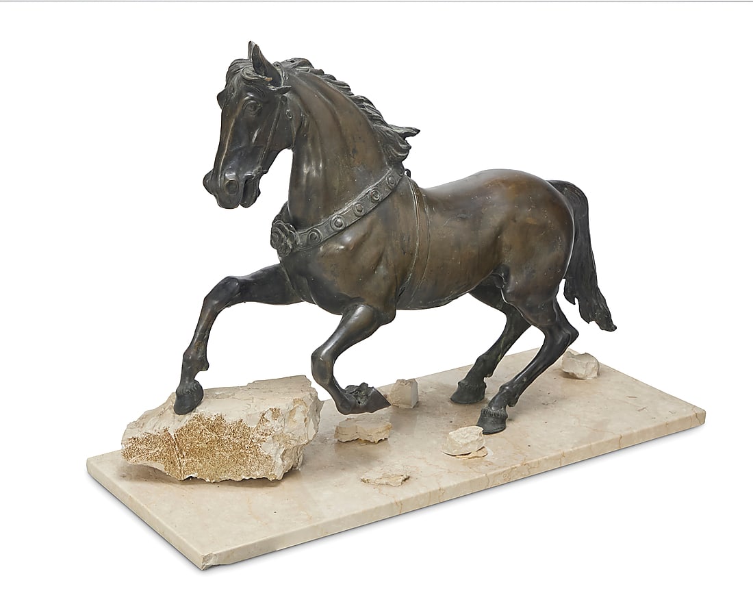 A patinated bronze model of a prancing horse: A patinated bronze model of a prancing horse 20th century Unmarked Mounted on a travertine base Bronze: 21.125" H x 27" W x 7.75" D; Overall: 21.75" H x 30" W x 12.25" D Provenance: Private Estate, Ca