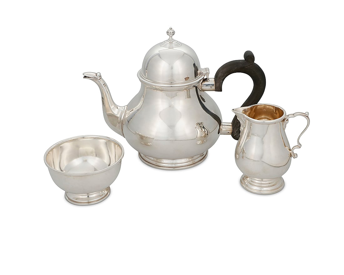 An assembled English sterling silver tea service: An assembled English sterling silver tea service Three works: A teapot with wood handle, 1973 With English hallmarks for sterling, Birmingham, date, and maker: B E S & Co. [Barker Ellis Silver Co];