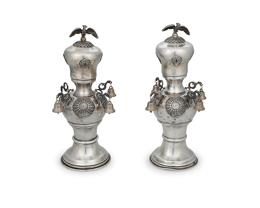 A pair of Continental sterling silver Rimonim: A pair of Continental sterling silver Rimonim Late 19th/early 20th century Each appears unmarked, XRF tested for sterling Each Torah scroll finial decorated with openwork scroll medallions, with drago