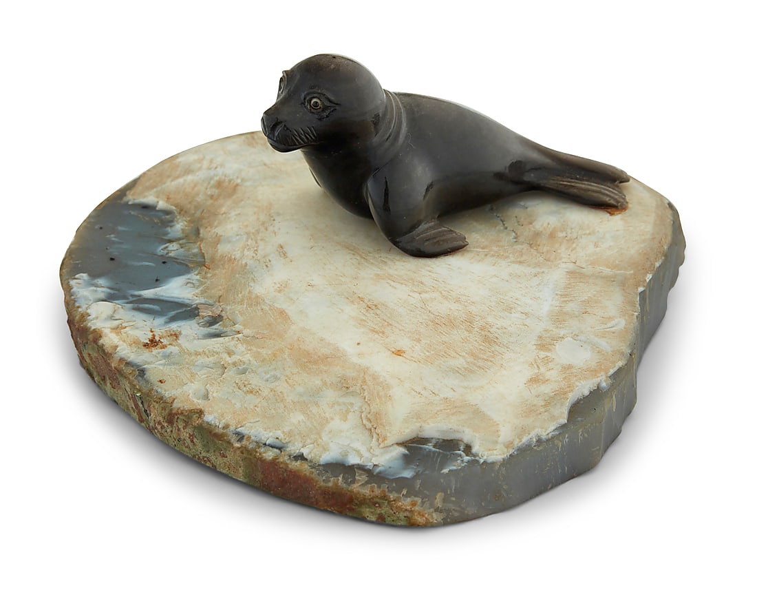 A carved hardstone model of a seal: A carved hardstone model of a seal Late 20th century With inset glass eyes, on a geode cross-section base Overall: 2.875" H x 7.25" W x 5.75" D