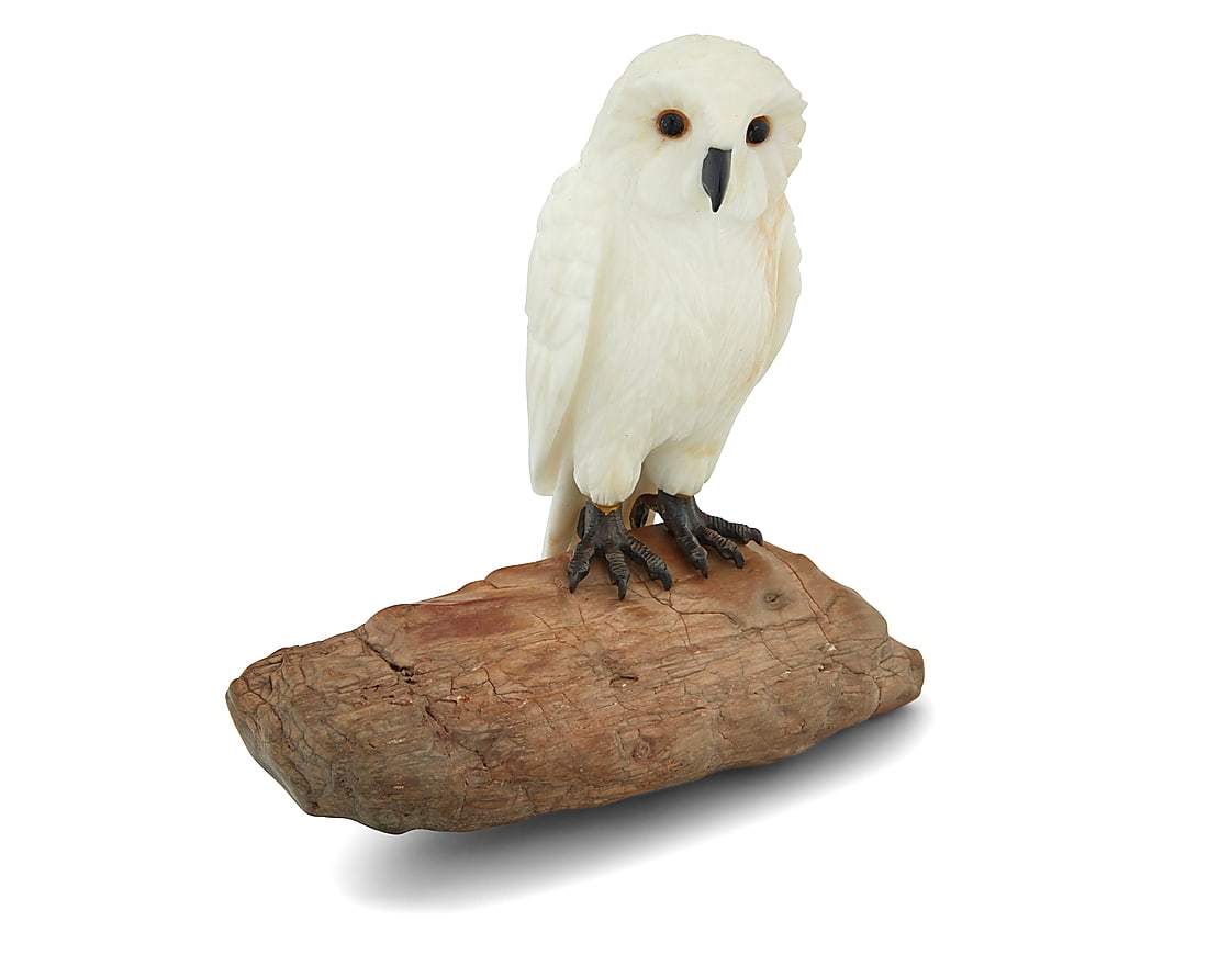 A carved white agate owl on petrified wood base: A carved white agate owl on petrified wood base Late 20th century With inset glass eyes Overall: 5.375" H x 5.375" W x 2.75" D