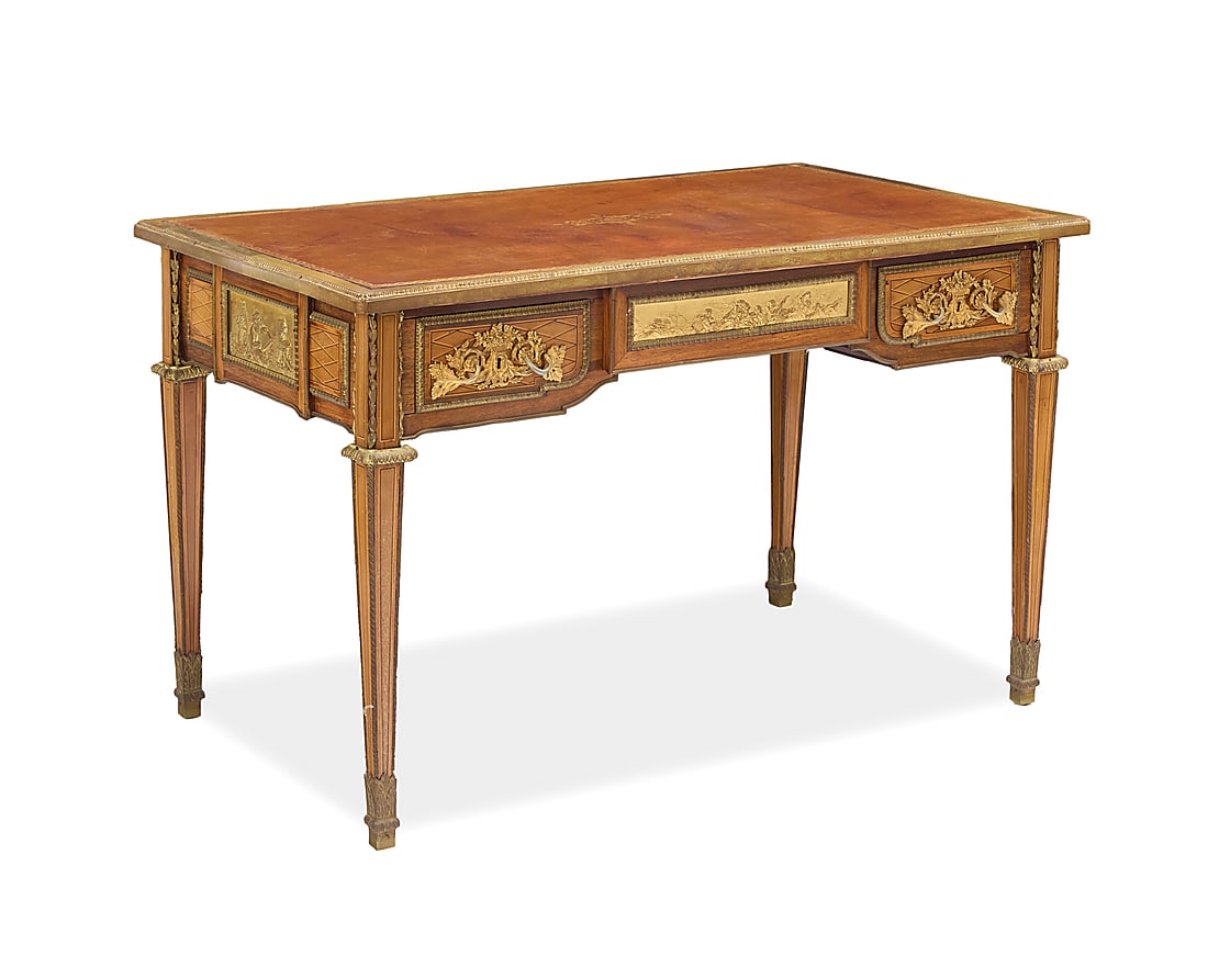 A Louis XVI style gilt bronze mounted writing desk: A Louis XVI style gilt bronze mounted writing desk Paul Sormani (1817-1877), second half 19th century Lock marked: P. SORMANI With gilt-tooled leather top above gilt bronze trim, friezes depicting put