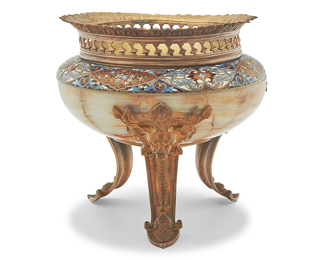A French champleve and gilt bronze mounted onyx centerpiece: A French champleve and gilt bronze mounted onyx centerpiece Circa 1870s With reticulated rim above a bronze interior, the onyx mounted with enameled foliate motifs, raised on lion's head mask chutes w