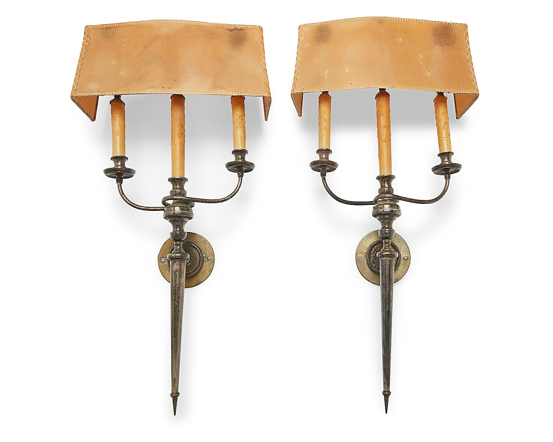 A pair of silver plated wall sconces: A pair of silver plated wall sconces 20th century Each unmarked Each issuing three lights with faux candle fixtures, with thick paper shade, electrified 2 pieces Each: 28.5" H x 14.5" W x 5" D