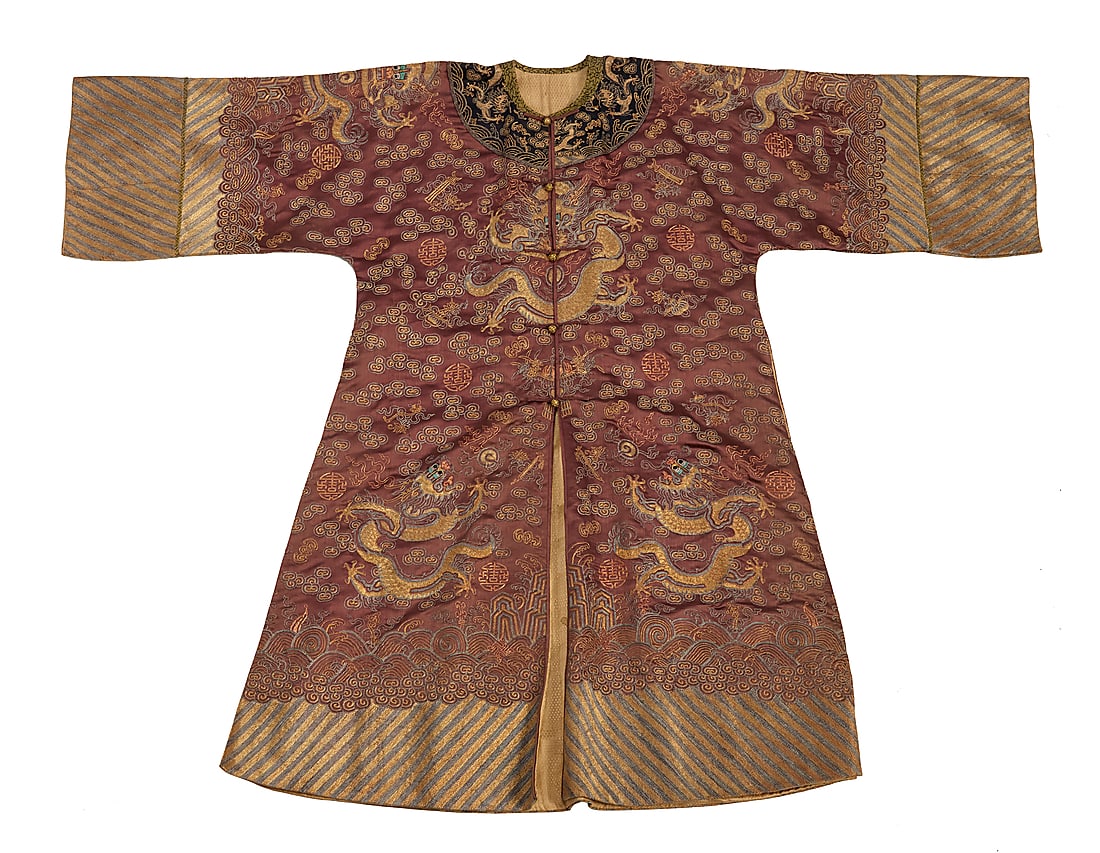 A Chinese embroidered silk Dragon robe: A Chinese embroidered silk Dragon robe Late Qing dynasty or later An elaborately embroidered pale rosewood brown silk robe with striped sleeves and dark collar, featuring eight dragons surrounded by e
