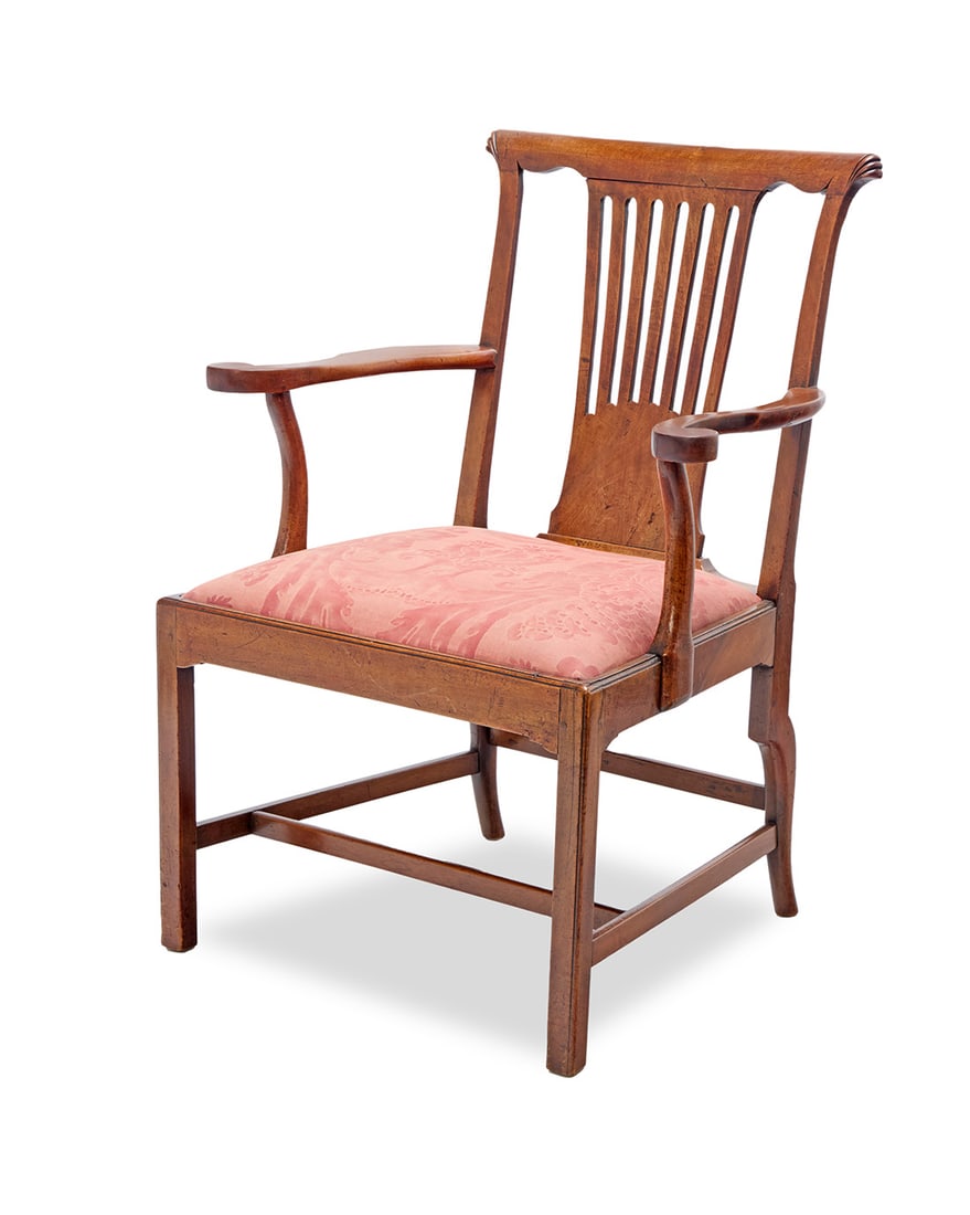 A George II mahogany open armchair: A George II mahogany open armchair 18th century With openwork back splat and carved accents to corners of crest rail, the seat later upholstered in a foliate pattern fabric 41" H x 31" W x 28" D