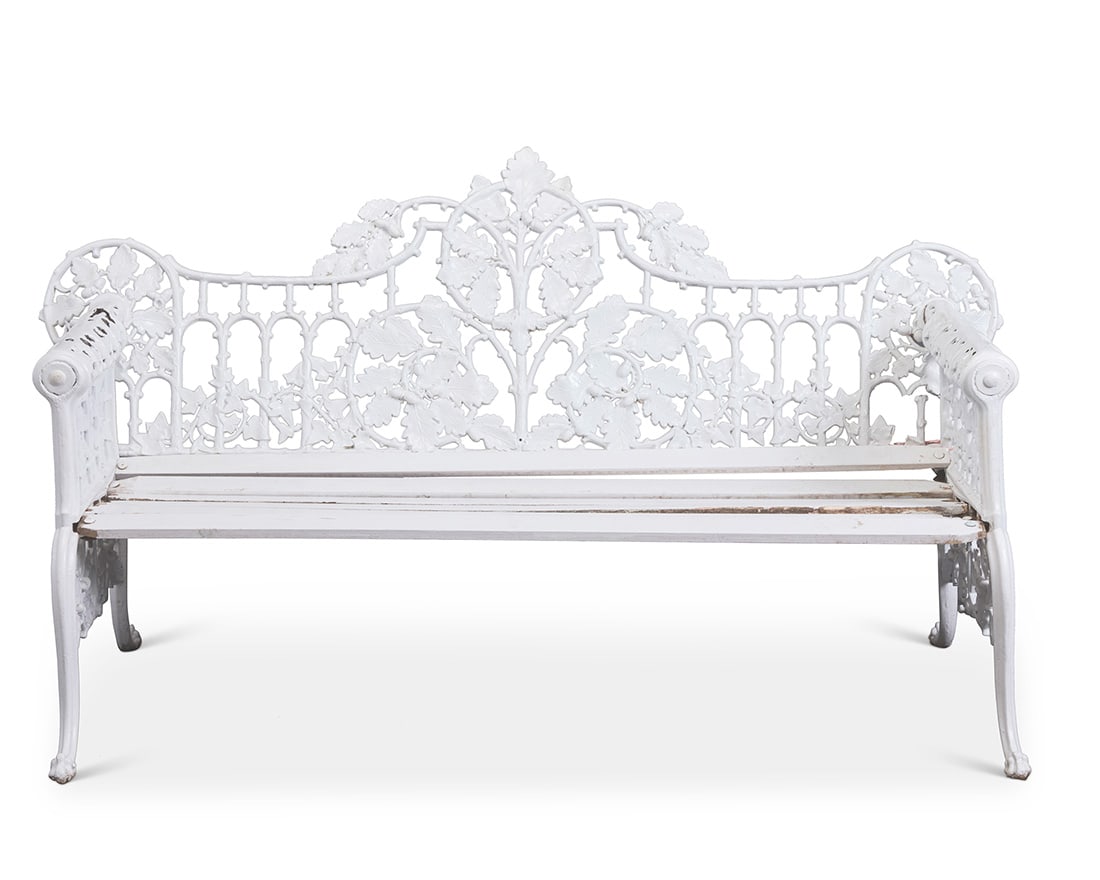 A Victorian Coalbrookdale style painted cast iron garden bench: A Victorian Coalbrookdale style painted cast iron garden bench Late 19th century With an oak leaf motif back, wood slat seat, and rolled armrests with dog head hand grips, raised on paw feet 38.5" H x