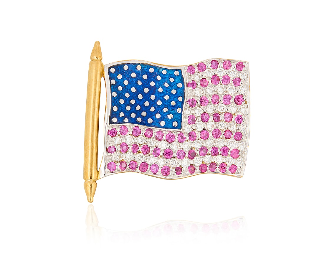 An 18K Gold, Diamond and Ruby Flag Pin: An 18K Gold, Diamond and Ruby Flag Pin Of an American flag design featuring blue enamel accented by round rubies and round diamonds Measures: 1 x 7/8 in. 3.6 grams gross This lot is being offered
