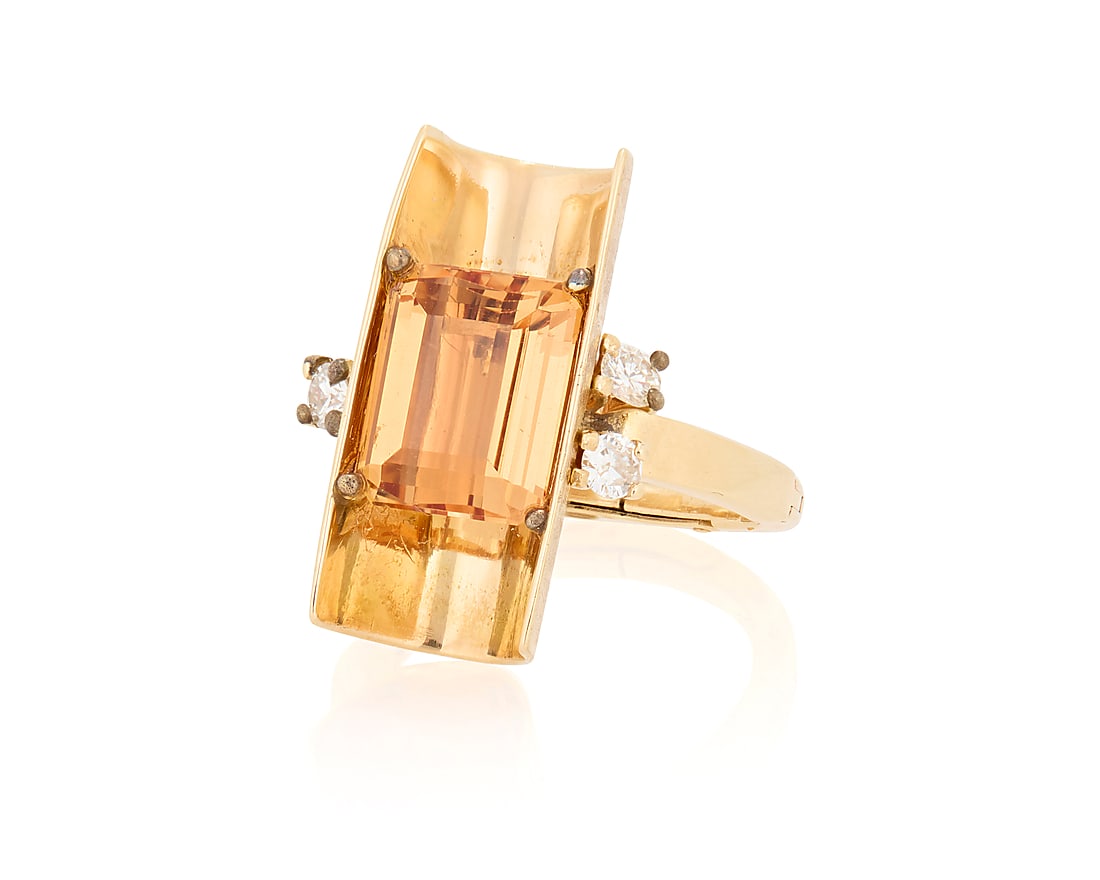 A 14K Gold and Topaz Ring: A 14K Gold and Topaz Ring Centering an emerald-cut topaz in an open cylindrical design accented by three round diamonds Size: 7 with hinged shank 7.6 grams gross