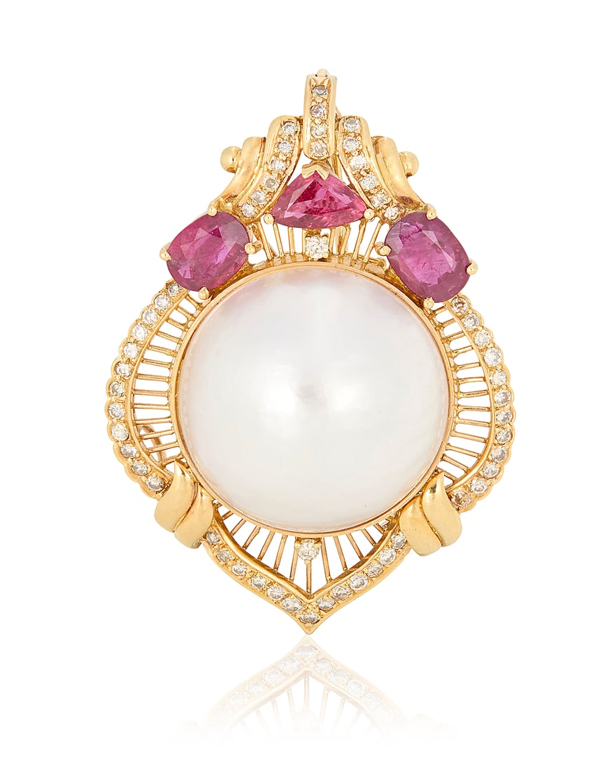 An 18K Gold, Mabe Pearl and Diamond Pendant/Brooch: An 18K Gold, Mabe Pearl and Diamond Pendant/Brooch Of an ornate frame design centering a mabe pearl measuring approximately 22.20 mm, accented by oval and triangular-cut rubies finished with round