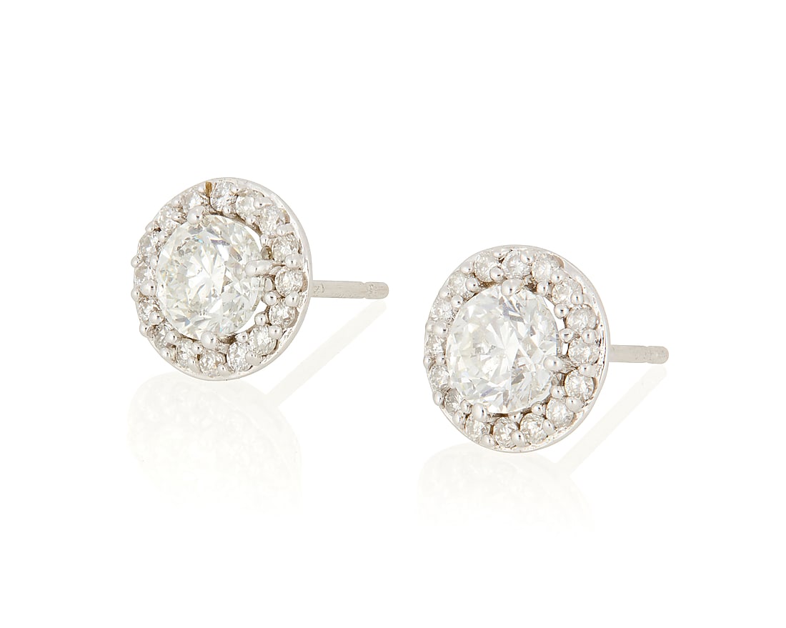 A Pair of White Gold and Diamond Stud Earrings: A Pair of White Gold and Diamond Stud Earrings Centering two round diamonds weighing approximately 0.65 carat each, encircled by round diamonds 2 pieces Measures: 3/8 in. 1.8 grams gross This lot is