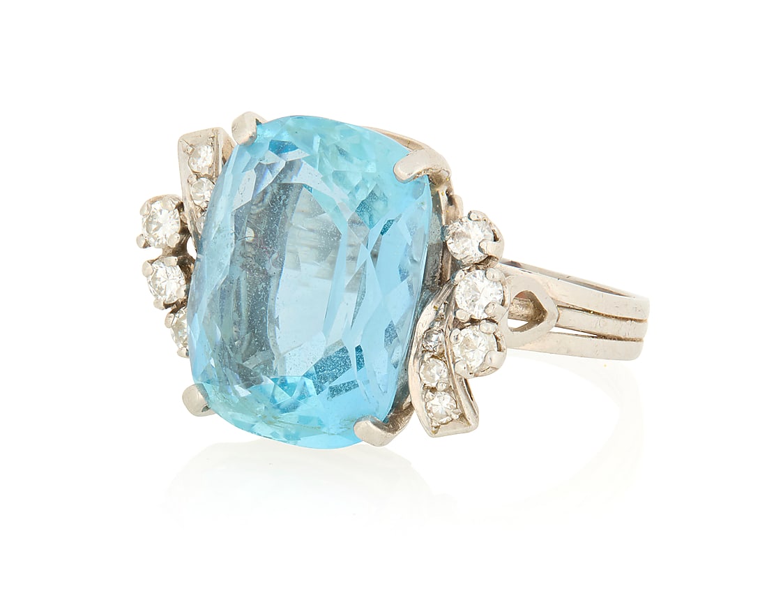 A Platinum, Aquamarine and Diamond Ring: A Platinum, Aquamarine and Diamond Ring Centering a rectangular cushion-cut aquamarine weighing approximately 8.79 carats, accented by round diamonds weighing approximately 0.36 carat Size: 5 6.9