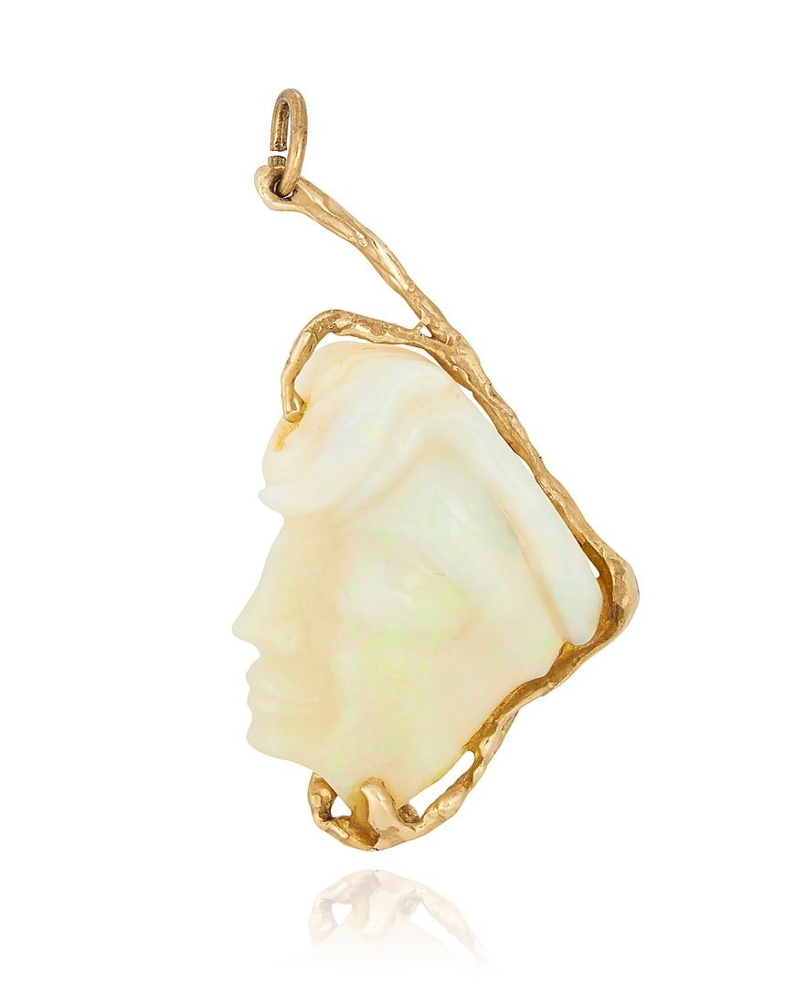 A 14K Gold and Opal Pendant: A 14K Gold and Opal Pendant Of an organic design featuring a carved opal of a woman's profile measuring approximately 40.00 x 30.00 x 6.27 mm Measures: 2 1/2 X 1 1/4 in. 16.0 grams gross Provenance: