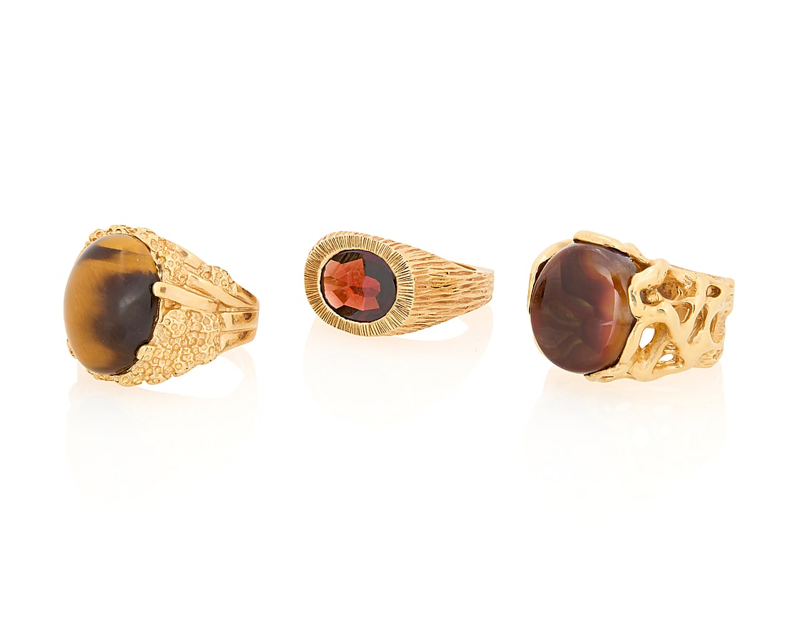 A Group of Three 14K Gold Rings: A Group of Three 14K Gold Rings Featuring organic designs centering an oval garnet, tiger's eye cabochon and Mexican fire agate cabochon 3 pieces Sizes: 8 3/4 and 9 45.9 grams gross