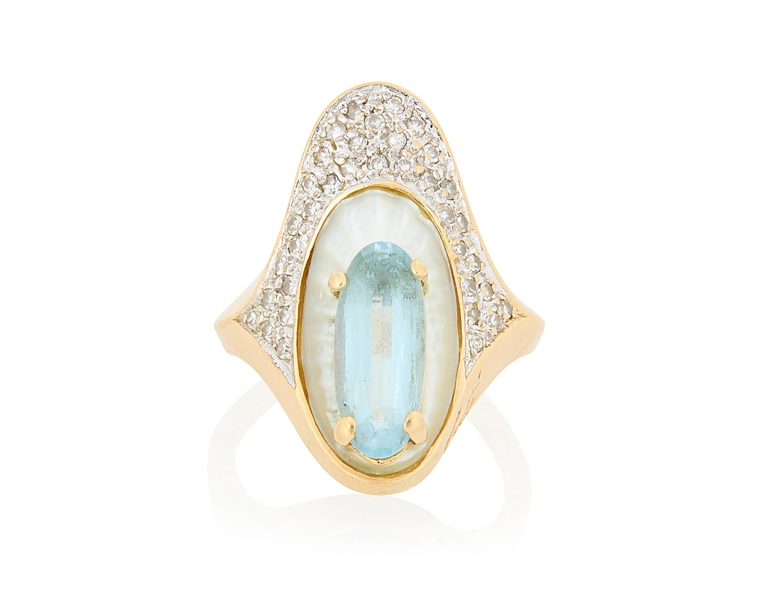 Erte: A 14K Gold, Gem-Set and Diamond Ring: Erte: A 14K Gold, Gem-Set and Diamond Ring Centering an oval blue topaz set in a carved mother-of-pearl element accented by round diamonds, signed Erte, CFA Size: 5 1/2 6.8 grams gross This lot is bei