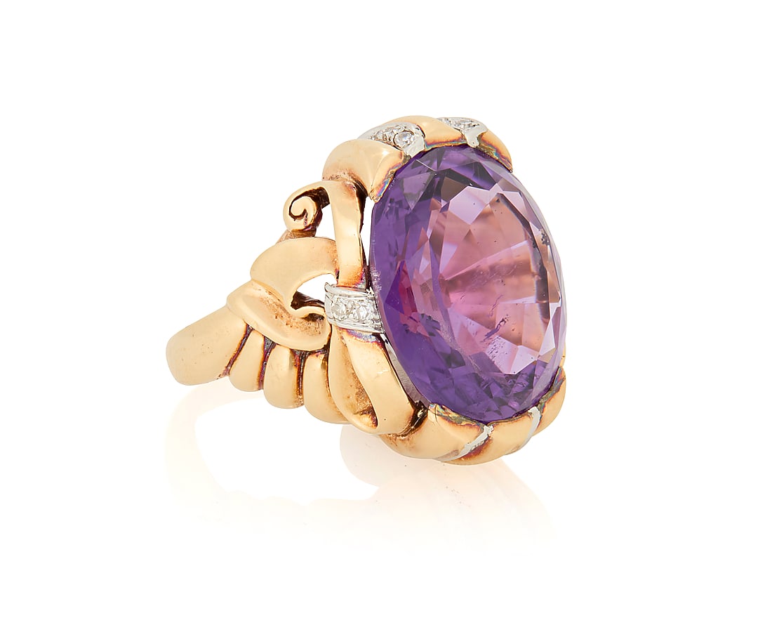 A 14K Bi-Color Gold, Amethyst and Diamond Ring: A 14K Bi-Color Gold, Amethyst and Diamond Ring Centering an oval amethyst weighing approximately 17.10 carats, accented by single-cut diamonds set in a swirling ribbon design Size: 8 18.2 grams gross 