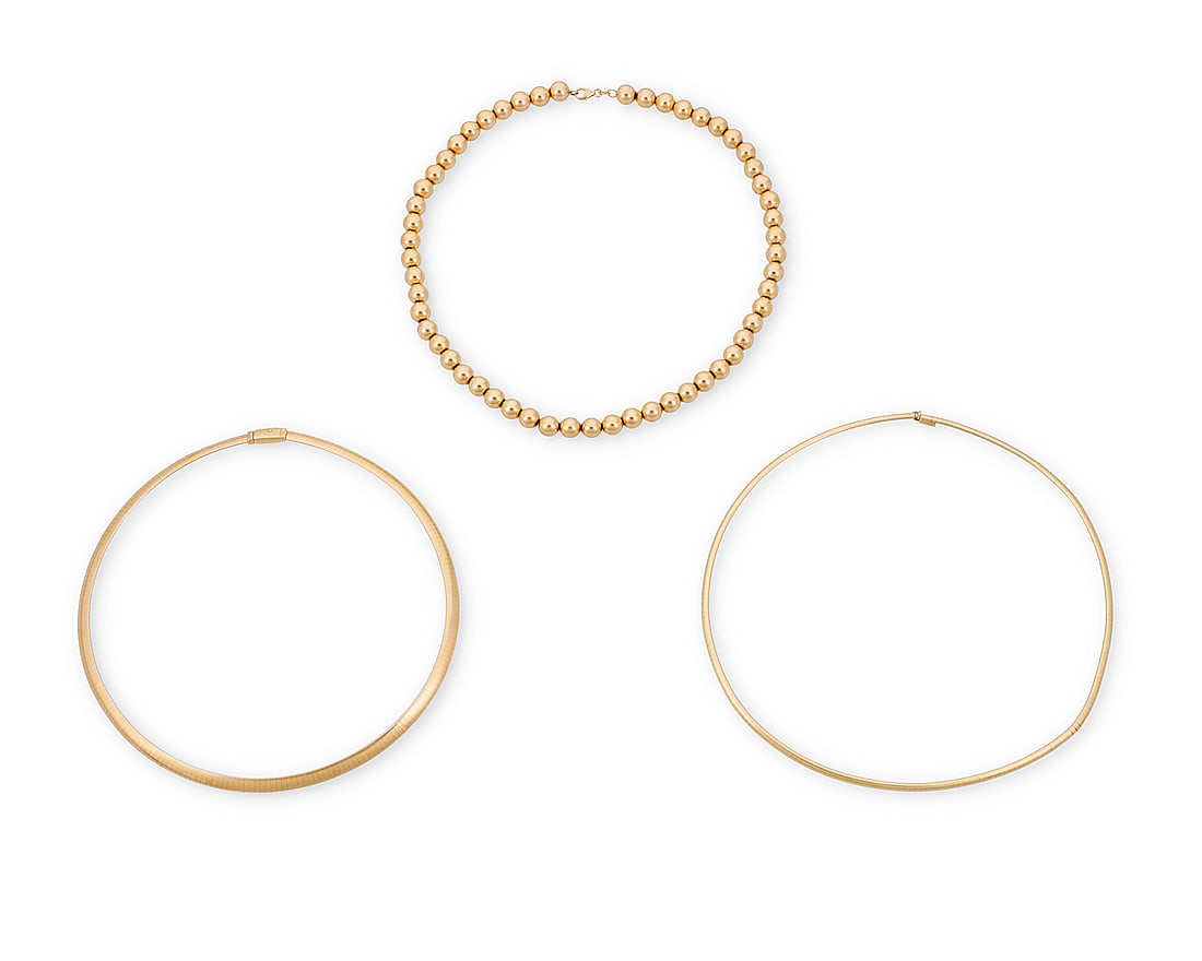 A Group of Three Bi-Color Gold Necklaces: A Group of Three Bi-Color Gold Necklaces Including a white gold and yellow gold omega collar necklace together with a 14k gold bead necklace 3 pieces Lengths: 16 1/2 in., 17 1/2 in. and 18 in. 75.0