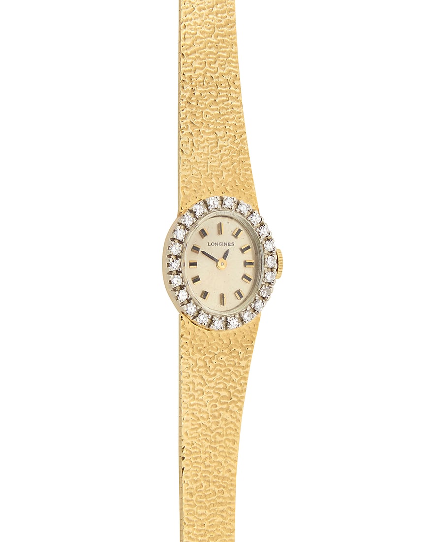Longines: A 14K Gold and Diamond Watch: Longines: A 14K Gold and Diamond Watch Dial: 11.92 mm, oval with baton hour markers, encircled by single-cut diamonds Case: 16.12 mm Closure: textured gold bracelet with notched clasp Signed: dial Inn