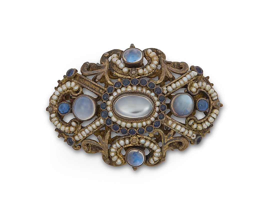 A Gold Filled and Gem-Set Brooch: A Gold Filled and Gem-Set Brooch Of an ornate design featuring oval and round moonstone cabochons accented by round sapphires and seed pearls Measures: 2 x 1 1/4 in. 17.6 grams gross This lot is