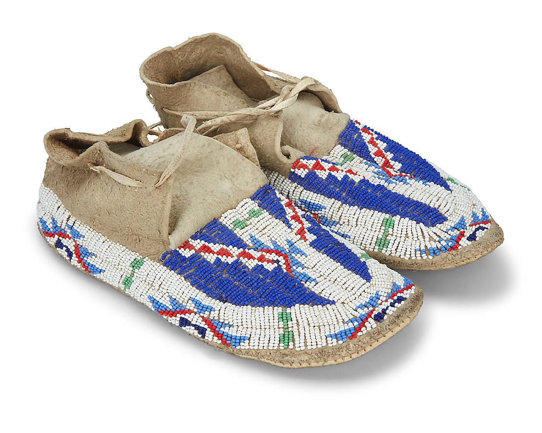 A pair of Plains beaded hide moccasins: A pair of Plains beaded hide moccasins Mid-20th century Each with polychrome beaded geometric designs 2 pieces Each: 10.375" L x 4.25" W Provenance: Private Estate, Southern California