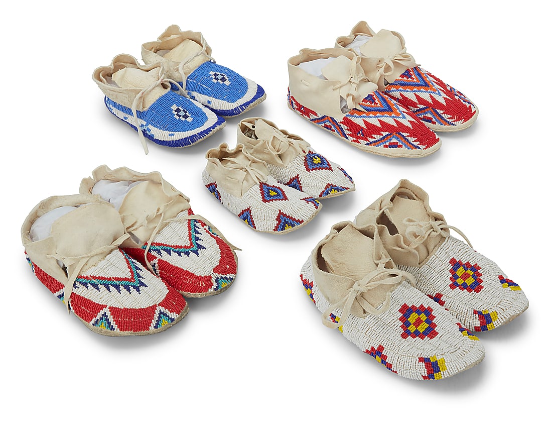 Five pairs of Plains beaded hide moccasins: Five pairs of Plains beaded hide moccasins Late 20th/early 21st century Each with polychrome beaded geometric designs 10 pieces Largest: 10.375" L x 4.125" W; Smallest: 7.375" L x 3.375" W Provenance: