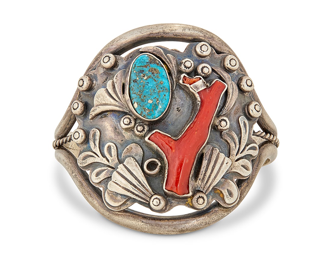 A Southwest sterling silver, turquoise, and coral cuff bracelet: A Southwest sterling silver, turquoise, and coral cuff bracelet Mid-20th century Unmarked A three wire cuff with central sterling plaque with set turquoise and branch coral, with applied silver foliat