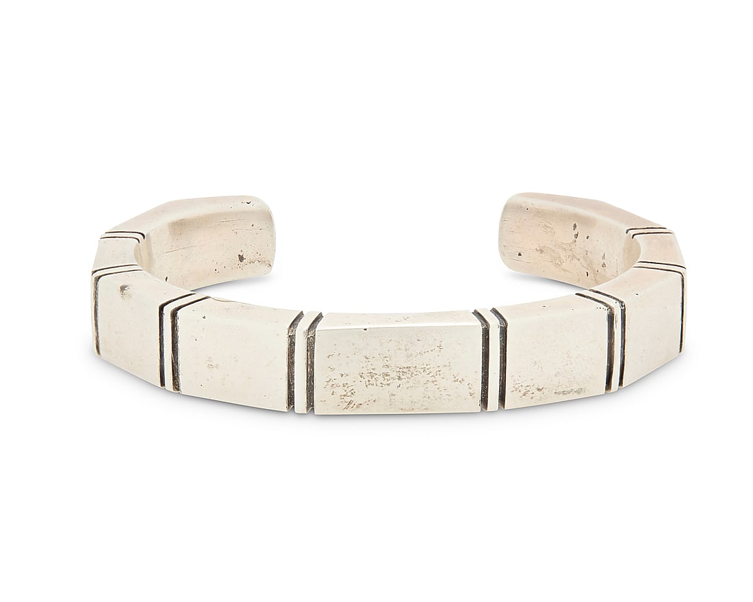 A Nusie Henry Belon Navajo sterling silver cuff bracelet: A Nusie Henry Belon Navajo sterling silver cuff bracelet Nusie Henry [Belon] (b. 20th century, Dine) Late 20th century Stamped: Nusie / Sterling A narrow modernist style angled cuff with incised bandi
