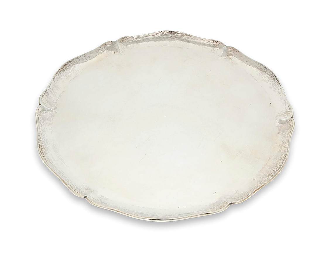 A Peruvian hammered sterling silver tray: A Peruvian hammered sterling silver tray Mid-20th century Impressed to underside: RLL / PL [indecipherable] / 925 / AMAND / Industria Peruana The round serving platter with a lobed rim 14.25" Dia.