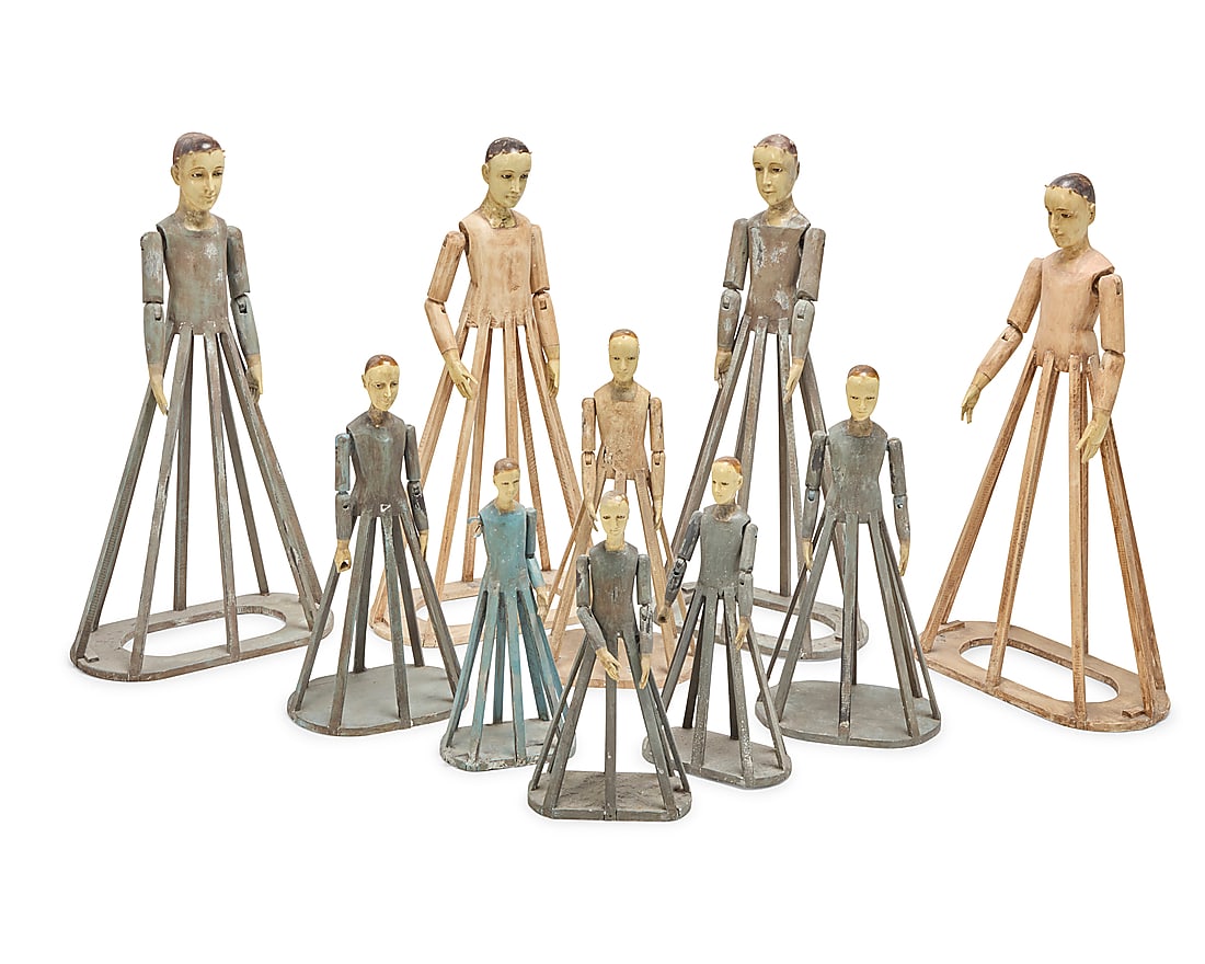 A group of ten Spanish Colonial-style cage doll santos: A group of ten Spanish Colonial-style cage doll santos 20th century Each painted carved wood, with inset glass eyes and articulated arms, most with pegs in the crown of the head 10 pieces Tallest: 39"