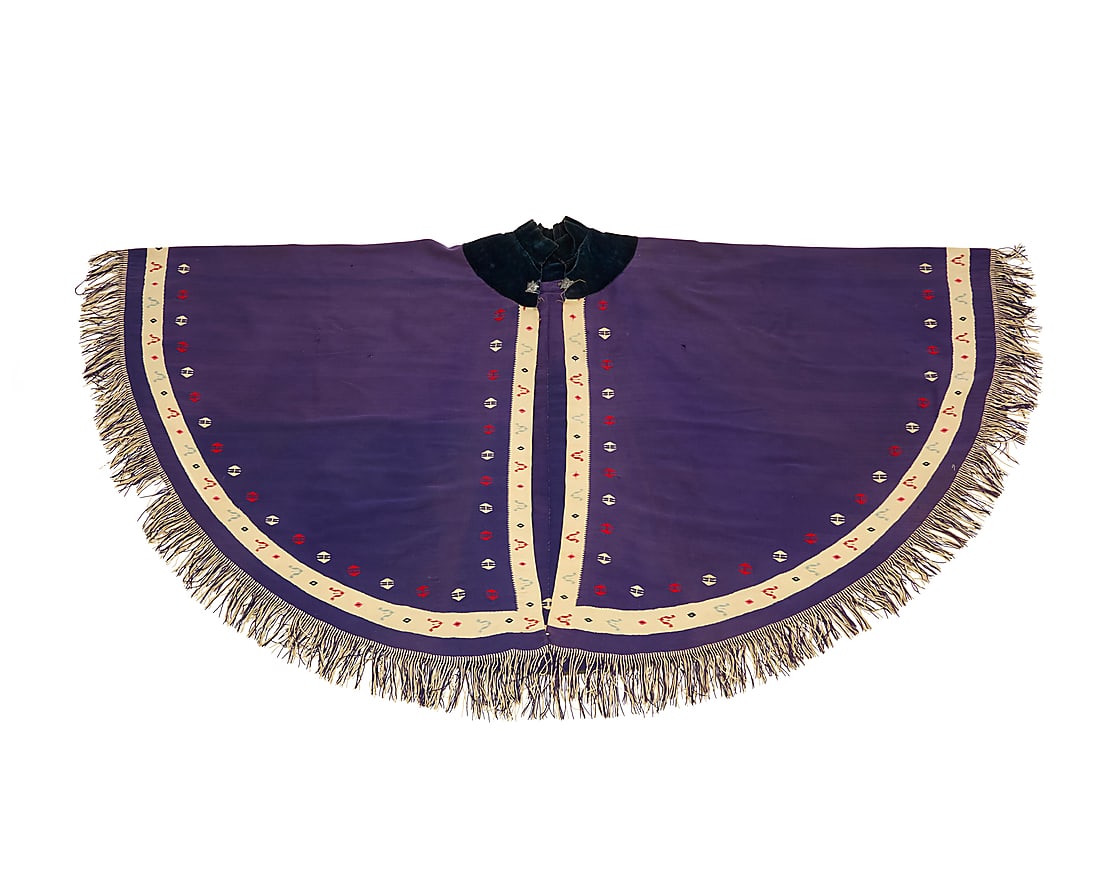 A rare Mexican Maximilian Period 'manga' cape: A rare Mexican Maximilian Period 'manga' cape Circa 1862-1870 The finely woven purple floss wool circular cape with center back seam, a narrow contrast ivory wool border with blue, red, and pink multi