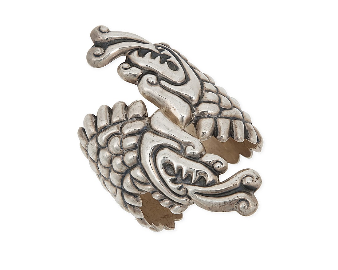A Mexican sterling silver Quetzalcoatl clapper bracelet: A Mexican sterling silver Quetzalcoatl clapper bracelet Late 20th century Stamped: Mexico / Nava / 925 The chunky hinged repousse silver cuff wrap bracelet with elaborate two-headed Quetzalcoatl feath