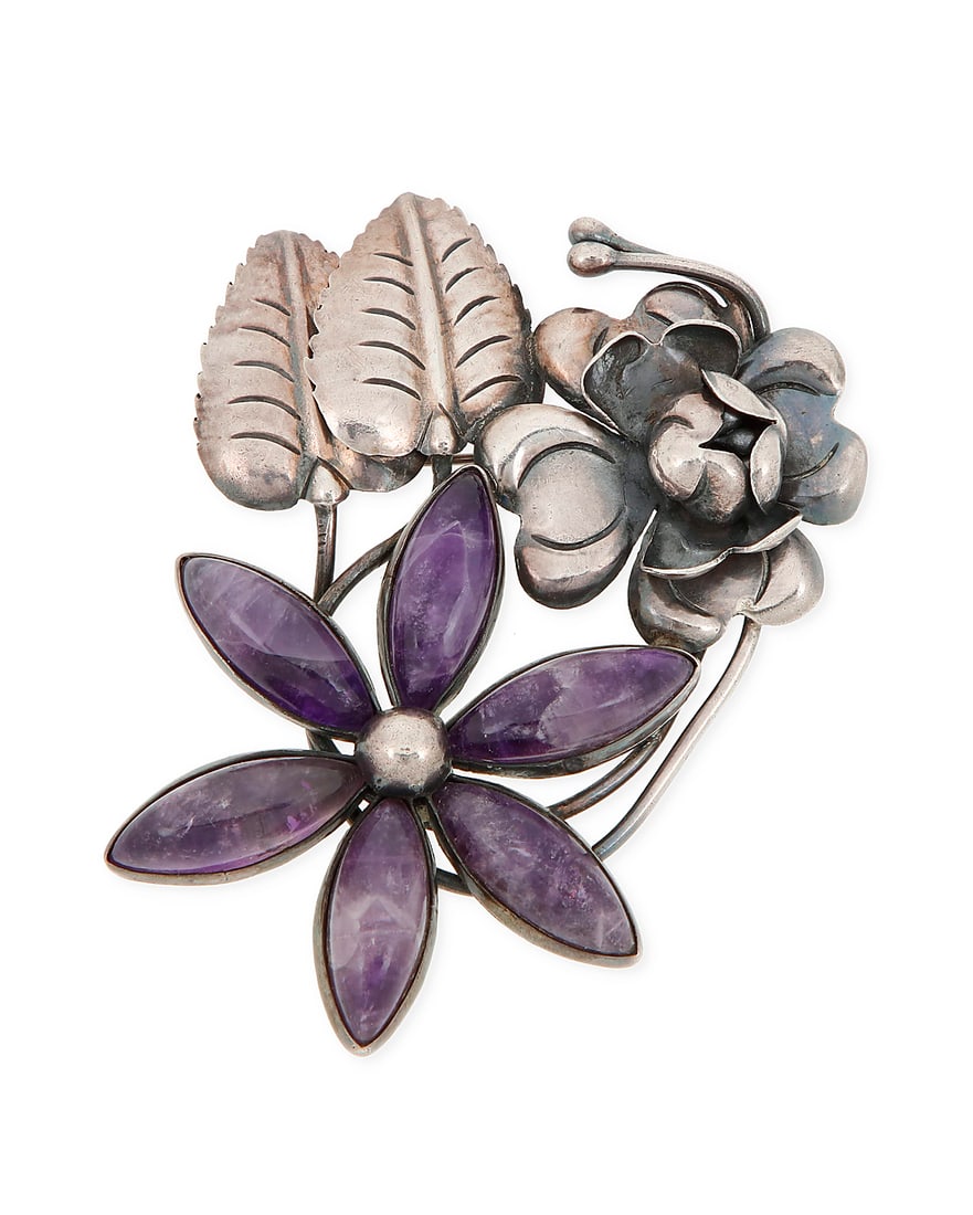 A Mexican silver and amethyst floral brooch: A Mexican silver and amethyst floral brooch Mid-20th century Stamped: Mexico / Silver A sterling silver brooch with incised leaves and a dimensional silver flower, and a flower with six set carved ame