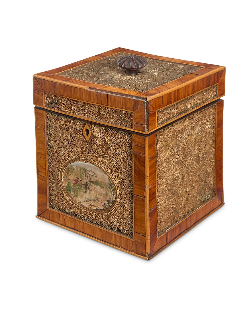 A George III rolled paper tea caddy Late 18th/early 19th century With painted fabric panel at: A George III rolled paper tea caddy Late 18th/early 19th century With painted fabric panel at front below a locking lid, the exterior inset with rolled paper filigree and floral designs 6.125" H x 5" 