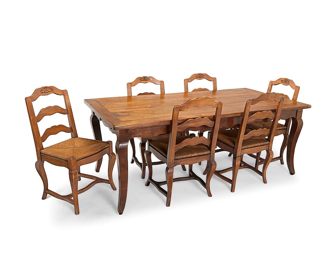 A French Provincial style carved walnut dining set 20th century The farmhouse table with six side: A French Provincial style carved walnut dining set 20th century The farmhouse table with six side chairs, each carved with floral elements to crest rail above a woven seat, raised on curved legs joine