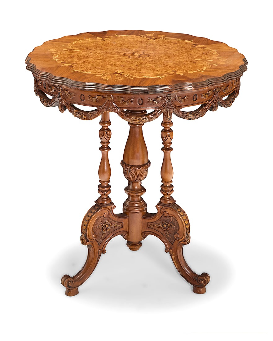 An Italian inlaid carved wood side table 20th century The inlaid top with piecrust edge, burlwood: An Italian inlaid carved wood side table 20th century The inlaid top with piecrust edge, burlwood veneer, and floral motif inlay, possibly married to turned supports and elaborately carved tripod legs